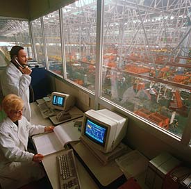 We provide pest control services for business, industry, and commercial enterprises. Image of two people reviewing an industrial production room.